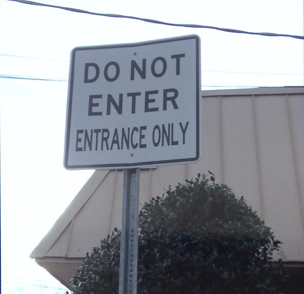 A photograph of a street sign that says "DO NOT ENTER, ENTRANCE ONLY"