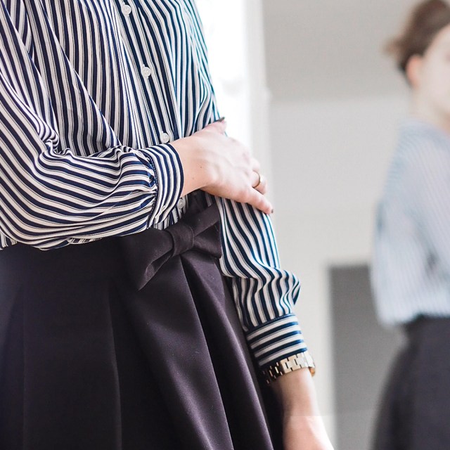 Photo of a woman looking at herself in the mirror, the reflection is blurred.