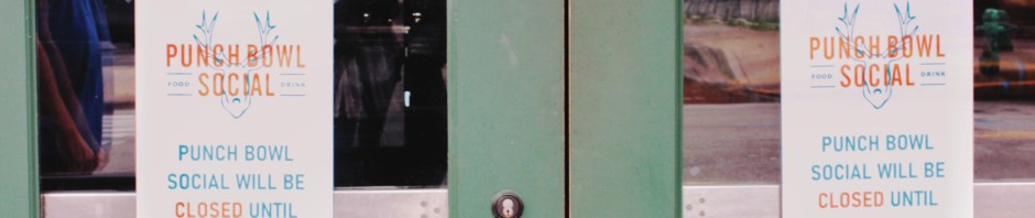 View of glass front doors of a coffee house that are chained and padlocked