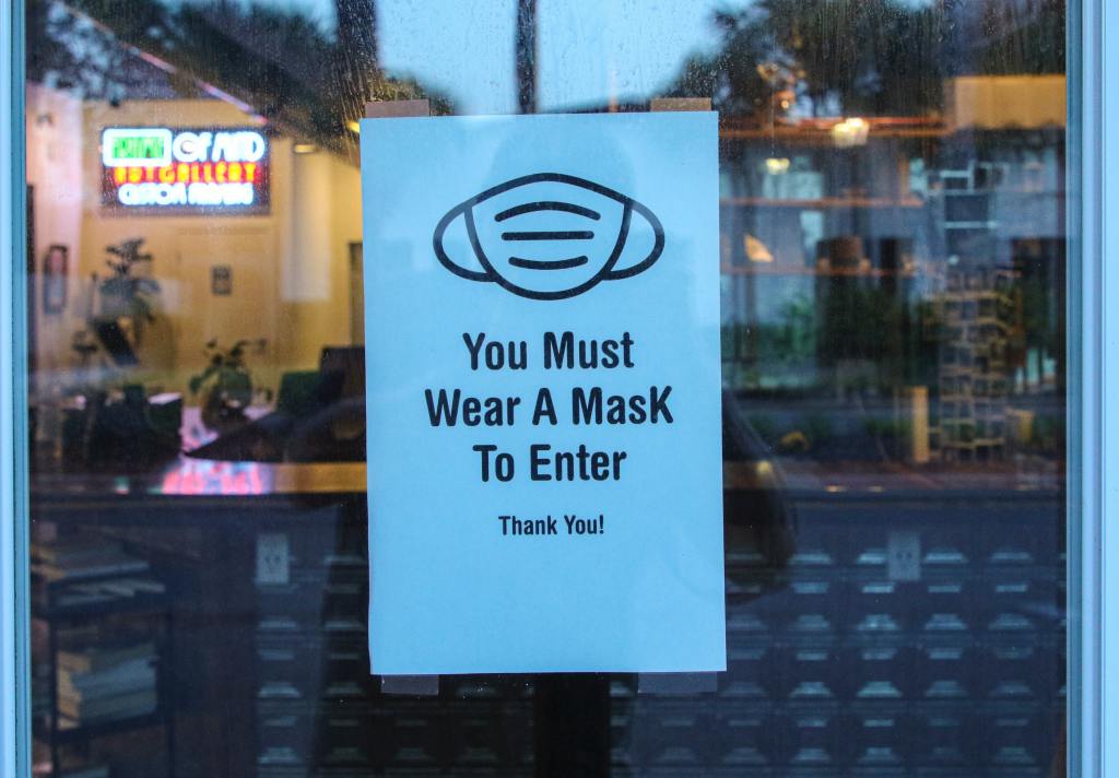Sign in store window that reads "You Must Wear A MasK To Enter"